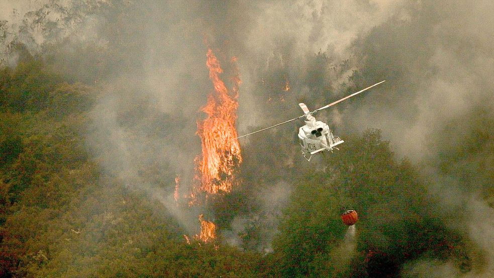 Ein Löschhubschrauber wirft Wasser über einem Feuer in der spanischen Provinz Ourense ab. Foto: Adrián Irago/EUROPA PRESS/dpa