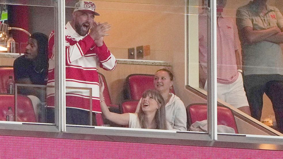 Er jubelt, sie wirft ihm einen verliebten Blick zu: Travis Kelce und Taylor Swift bei einem College-Football-Spiel. Foto: Charlie Riedel/AP/dpa