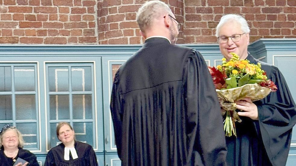 Pastor Klemens Niemann überreichte seinem Kollegen Stefan Schneider zum Abschied einen bunten Blumenstrauß. Foto: Kirchenkreis Norden