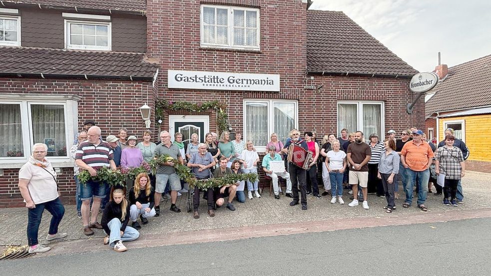 Rund 40 Simonswoldmer waren am Mittwoch zusammengekommen, um einen Ehrenbogen an der Gaststätte „Germania“ anzubringen. Foto: Imke Cirksena