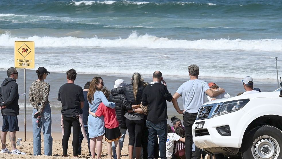 Schockierte Familienangehörige und Freunde trauerten am Strand um das Opfer. Foto: Dean Lewins/AAP/dpa