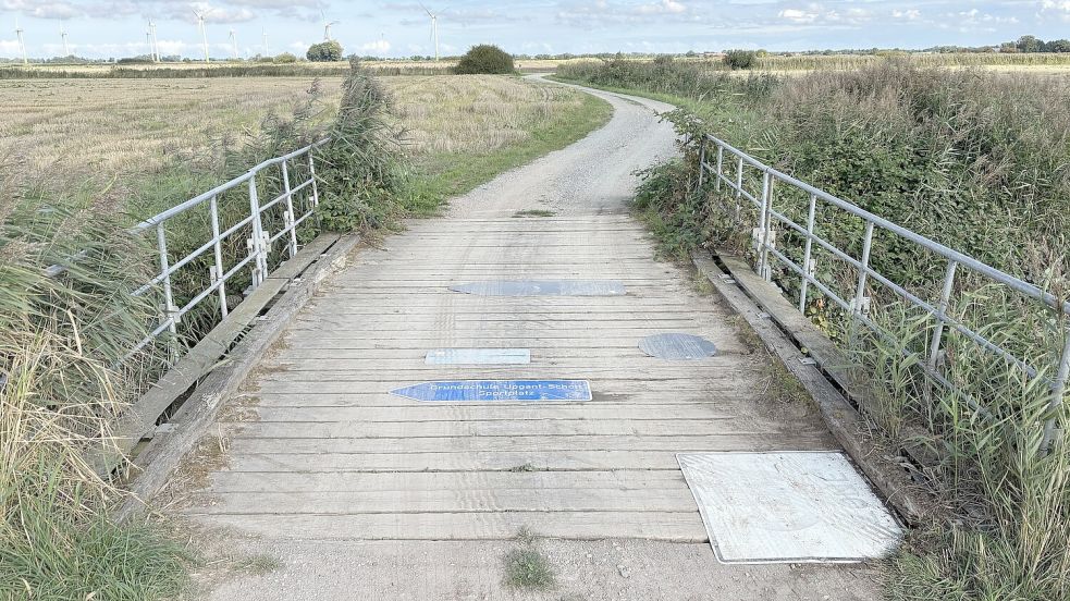 Löcher in den Holzbohlen dieser Brücke in Upgant-Schott wurden provisorisch mit alten Hinweis- und Verkehrsschildern abgedeckt. Foto: Thomas Dirks