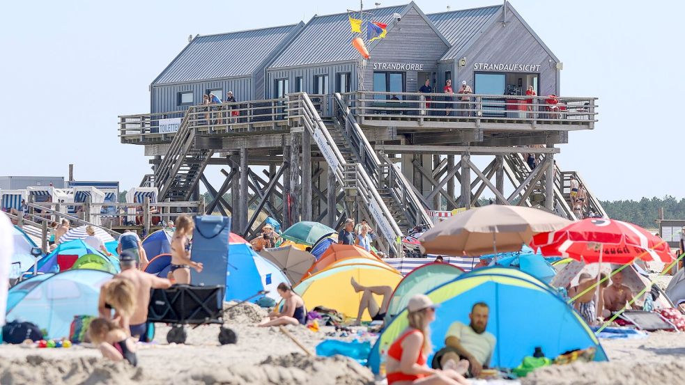 St. Peter Ording: Besucher verbringen am Strand einen heißen Sommertag. Dass Parken, Übernachten und Essengehen mittlerweile mehr kostet, sorgt für Kritik. Foto: dpa/Bodo Marks