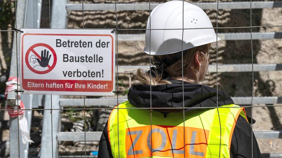 Ein Zollbeamter durchsucht eine Baustelle auf Schwarzarbeit. Foto: AFP/JOHN MACDOUGALL