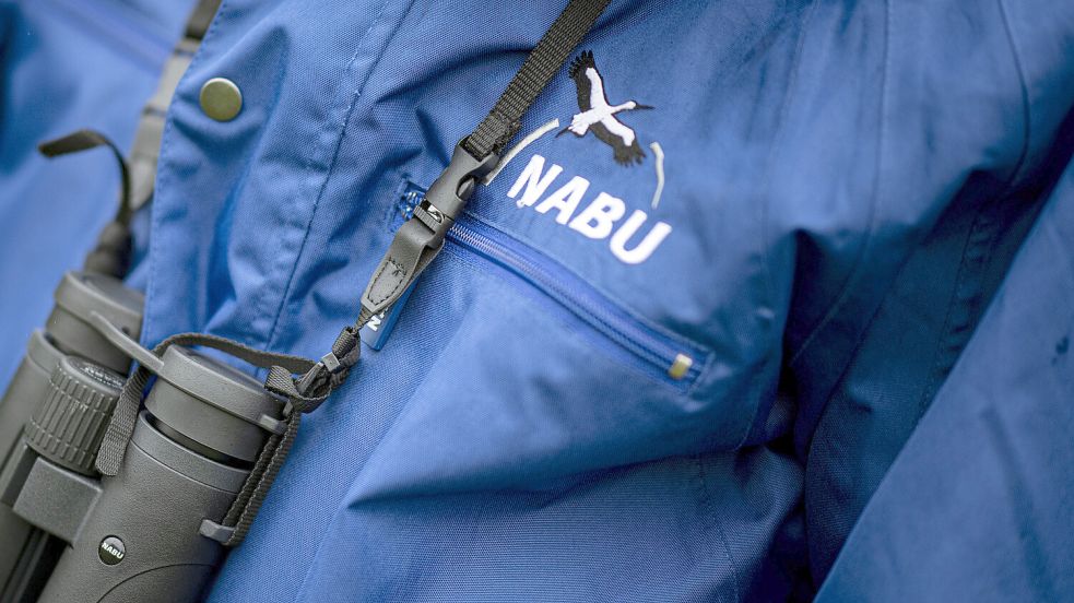Ein Nabu-Mitarbeiter mit einem Fernglas. Foto: Fabian Sommer/DPA