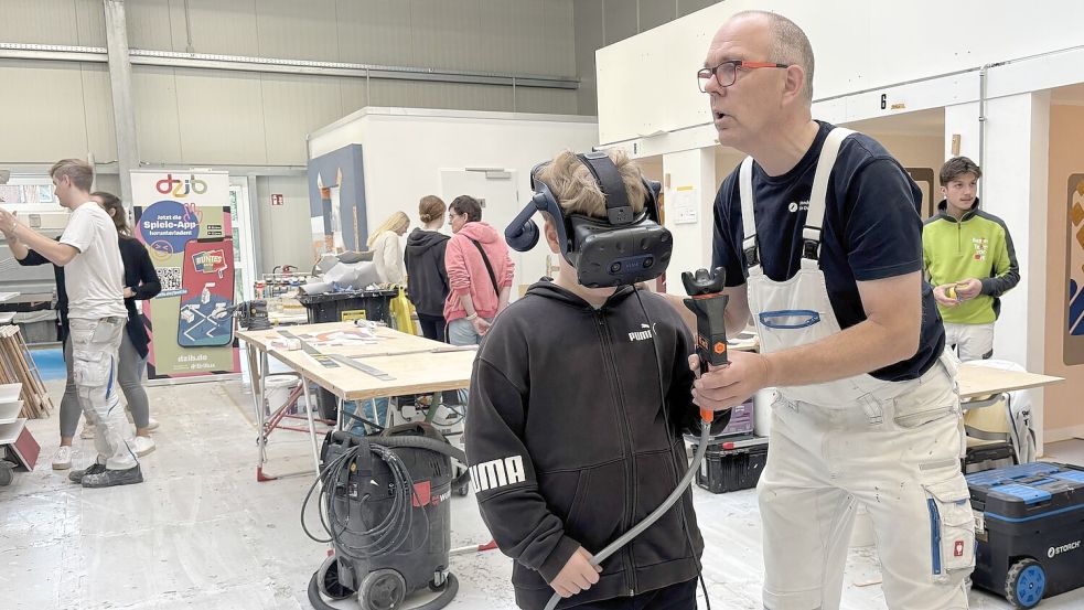 Ausbilder Wolfgang Post zeigt dem zwölfjährigen Lukas, wie der Lackiersimulator funktioniert. Foto: Mieke Matthes