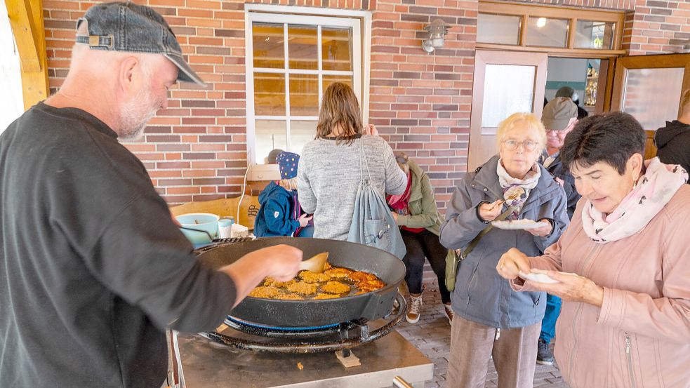 Heimatvereinsmitglied Heinz Kröger servierte Apfelreibekuchen aus der Pfanne. Foto: Folkert Bents