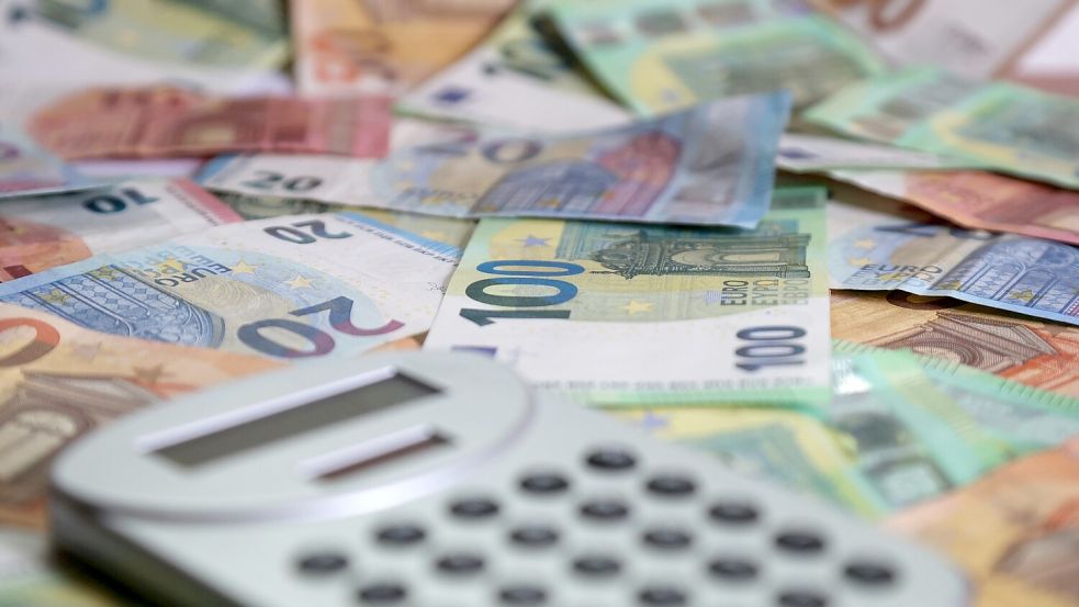 Ein Taschenrechner liegt neben Geldscheinen. Die Gemeinde Ihlow steht vor einer ungewissen finanziellen Zukunft. Foto: DPA