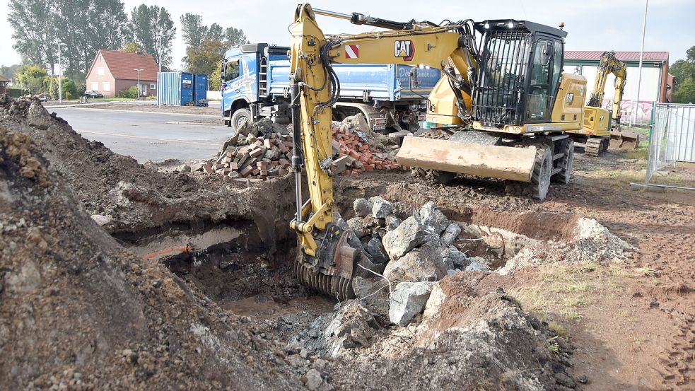 Ein Bagger entfernt am Sportplatz Osteel das zuvor zerkleinerte Fundament eines Flutmastes und verlädt die Betonteile auf einen Lastwagen. Foto: Thomas Dirks