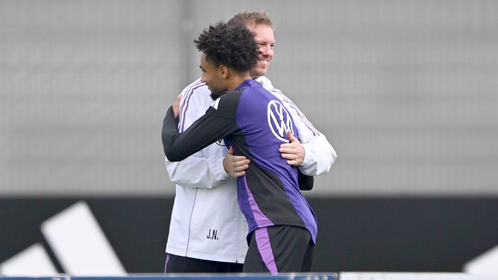 Bundestrainer Julian Nagelsmann begrüßt den nachnominierten Stürmer Kevin Schade auf dem Trainingsplatz. Foto: Federico Gambarini