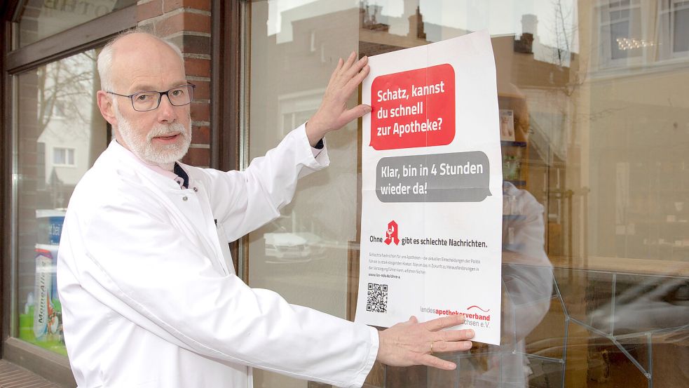 Berend Groeneveld, Vorsitzender des Landesapothekerverbandes, hängt an seiner Rats-Apotheke in Norden ein Plakat auf. Mit den markigen Sprüchen machte der Verband schon 2023 auf die Situation der Apotheken aufmerksam. Foto: LAV/Fotostudio Ekkenga