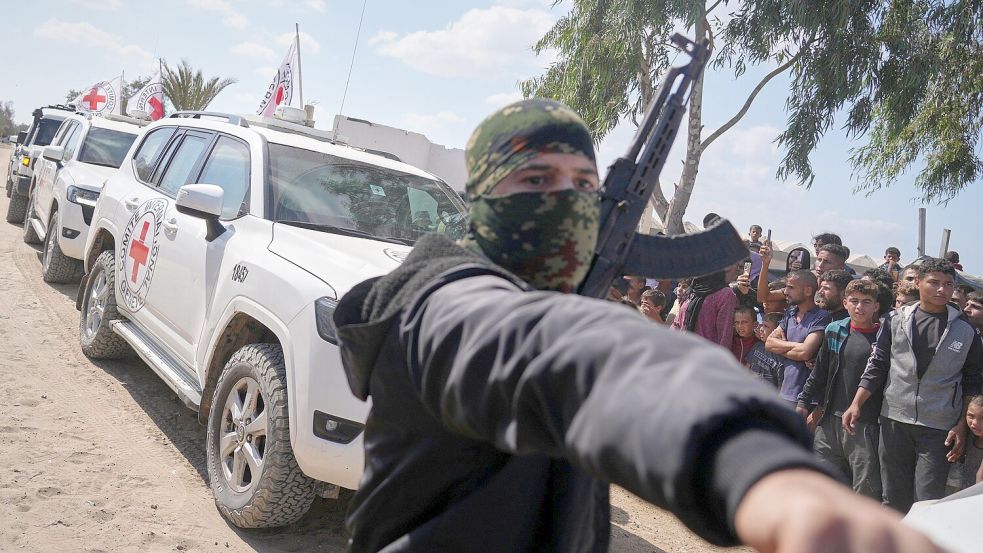 Fahrzeuge des Roten Kreuzes mit freigelassenen Geiseln bahnen sich ihren Weg durch Gruppen von Palästinensern und Hamas-Bewaffneten. Ihre Behandlung begann unverzüglich nach der Übergabe. Foto: dpa/ Jehad Alshrafi