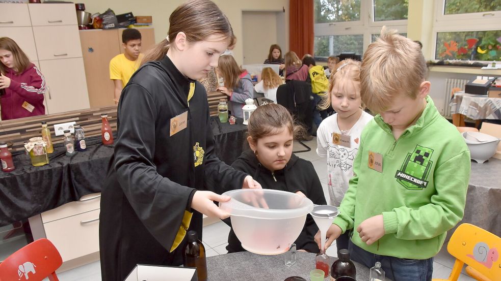 Mit vereinten Kräften füllen diese Kinder einen zuvor von ihnen gemixten „Lachtrunk“ in Fläschen. Foto: Thomas Dirks