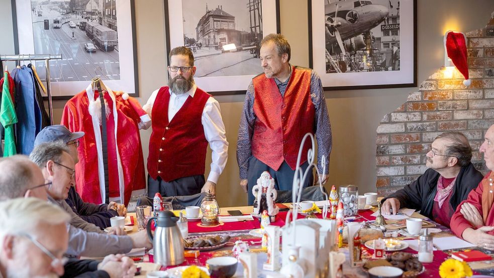 Markus von Juterczenka (links) zeigt ein besonders billiges Weihnachtsmannkostüm, von dem dringen abgeraten wird. Foto: Thomas Banneyer