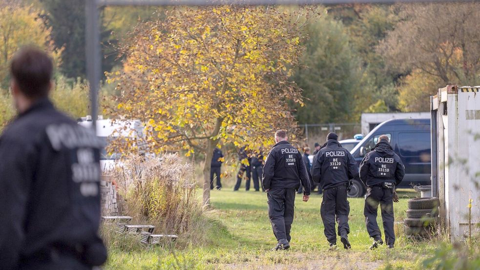 Polizisten stehen bei dem Großeinsatz auf einem Grundstück. (Archivbild) Foto: Christophe Gateau