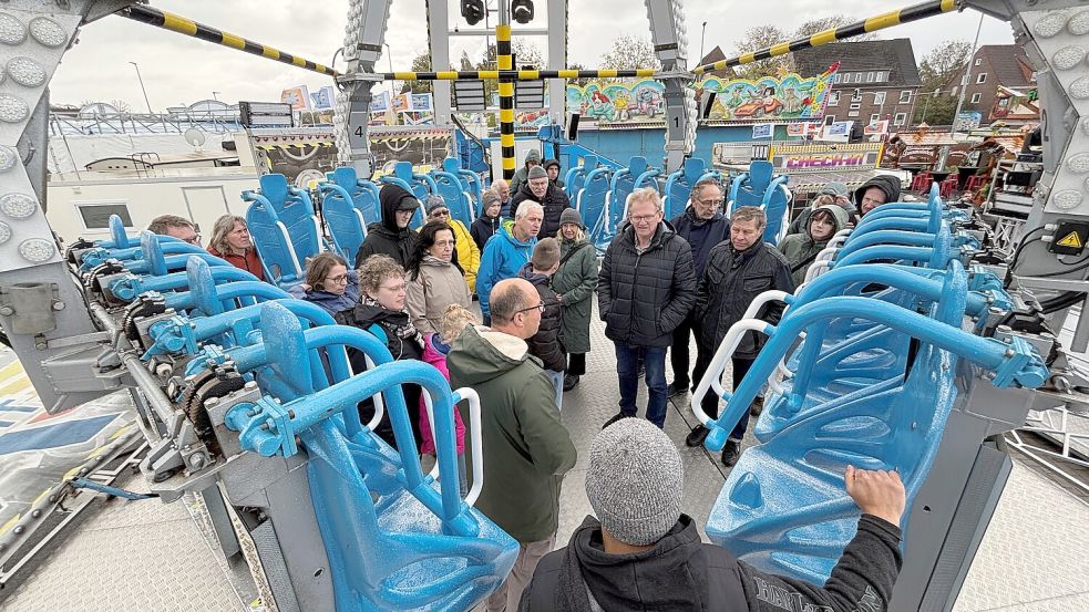 Wird oft unterschätzt: Schausteller Gino Ernst (mit grünem Anorak) erzählt von den rasanten Fahrten, die man mit seinem Fahrgeschäft „X-Flight“ erleben kann und davon, dass der eine oder andere Gast den Verzehr der Bratwurst später bereut habe. Foto: Udo Hippen