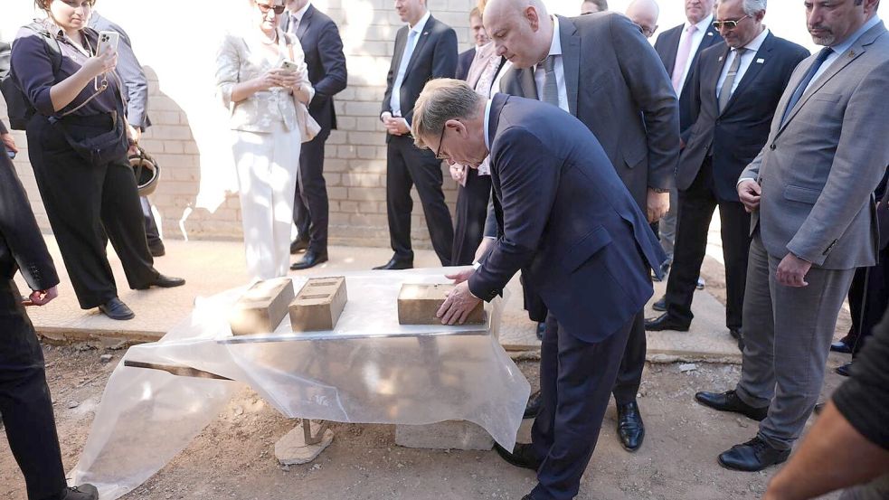 Außenminister Johann Wadephul (CDU) macht sich ein Bild von einem Projekt, das Binnenvertriebenen ermöglichen soll, günstig mit Lehmziegeln zu bauen. Foto: Marcus Brandt/dpa