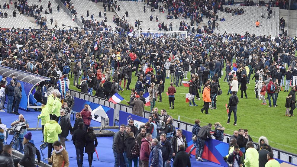 Nach dem Bekanntwerden der Anschläge am 13. November 2015 in Paris strömen Zuschauer in den Innenraum des Stade de France. Foto: IMAGO/Ulmer