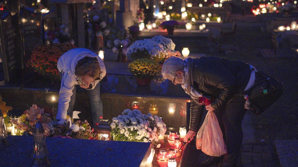 An Allerheiligen, einem der wichtigsten Feiertage in Polen, wird traditionell den Toten gedacht, indem Kerzen und Schmuck ans Grab gebracht werden. Foto: IMAGO/Xinhua