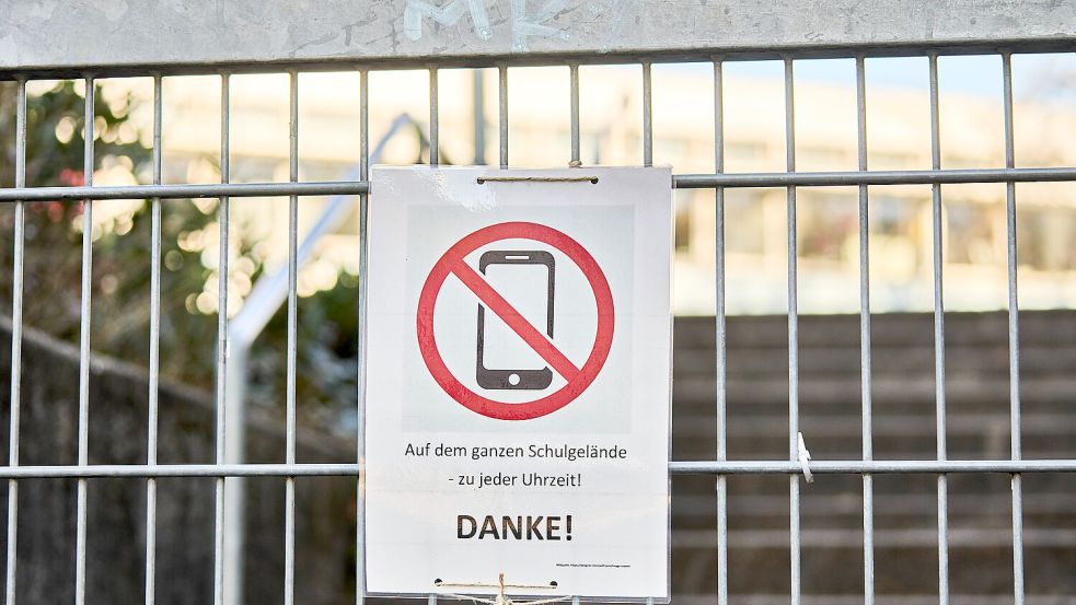 Ein Schild am Eingang eines Schulgeländes weist auf ein generelles Handyverbot hin. Gilt das bald auch in Niedersachsen? Foto: IMAGO/Bihlmayerfotografie