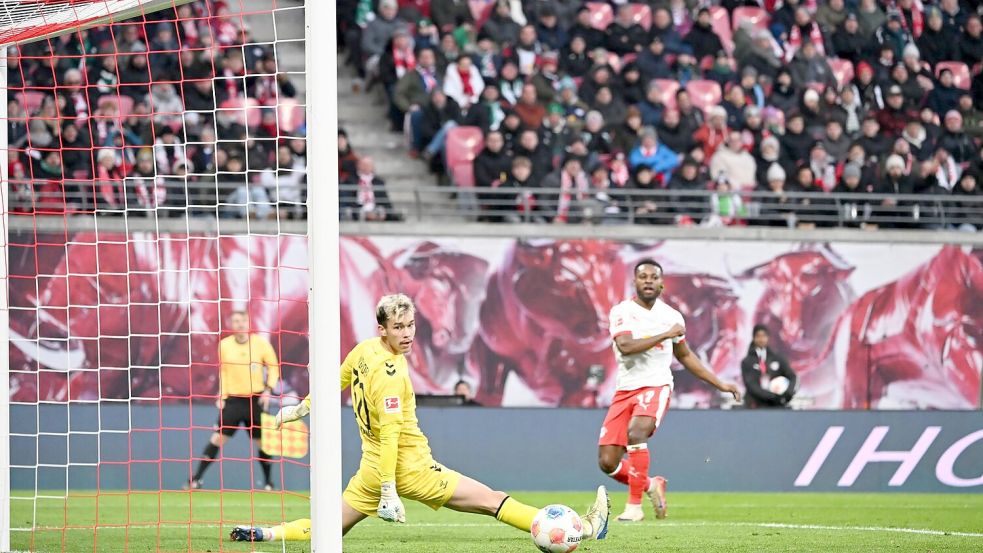 Bremens Torwart Mio Backhaus (l, Werder Bremen) und Ridle Baku (RB Leipzig) schauen dem Ball hinterher. Backhaus verhinderte mit seinen Paraden einen frühen Rückstand der Gäste in Leipzig. Foto: Jennifer Brückner