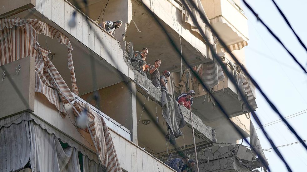 Mitglieder des libanesischen Zivilschutzes untersuchen Schäden in getroffener Wohnung in südlichem Vorort von Beirut. Foto: Bilal Hussein/AP/dpa