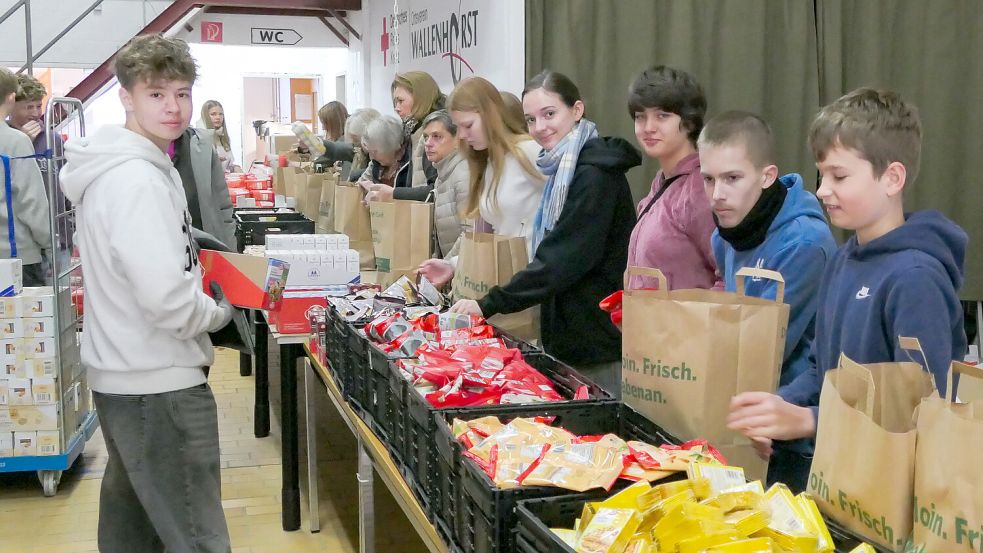 Einsatz zeigen diese Schüler beim Packen der Tüten für die Tafel in der Halle des DRK in Wallenhorst-Hollage. Foto: Christoph Beyer