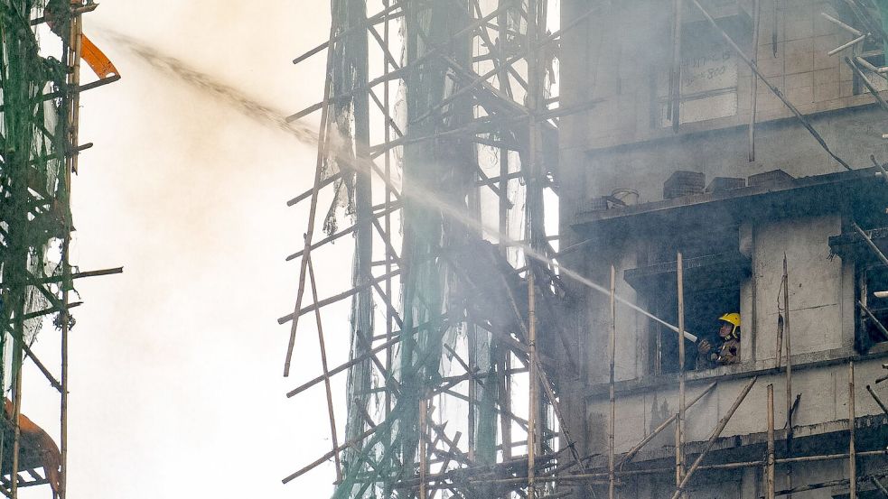 Bambus-Gerüste haben den Brand wohl beschleunigt. Foto: Chan Long Hei/AP/dpa