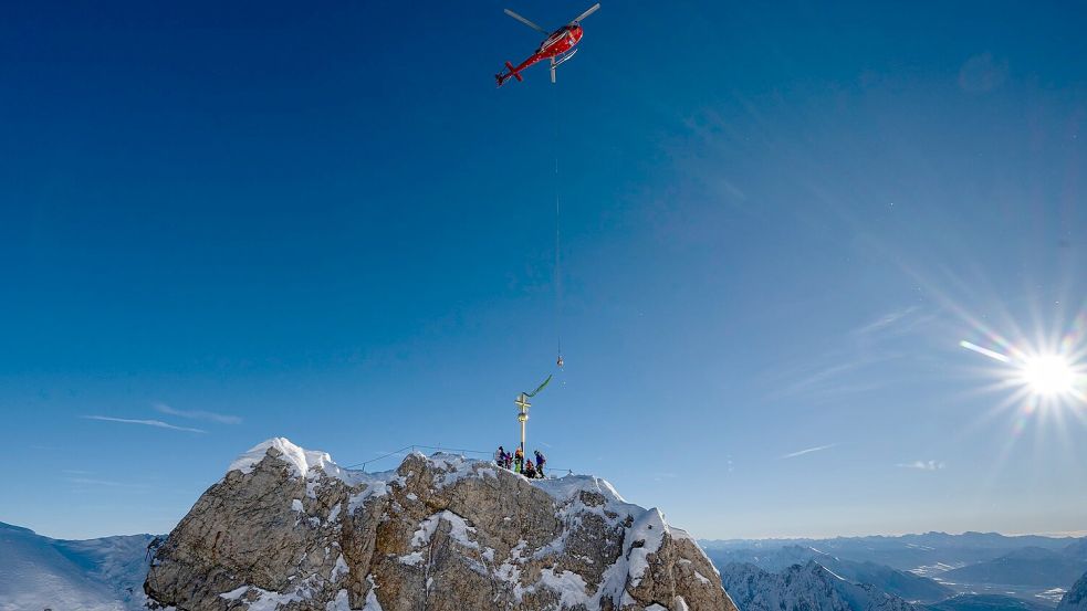 Das Kreuz schwebt am Gipfel ein. Foto: Peter Kneffel/dpa