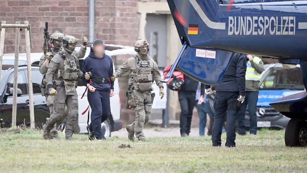 Eine Person wird von Polizeibeamten zu einem Hubschrauber gebracht. Foto: Uli Deck