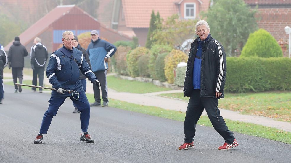 Die Mannschaftsführer Wilhelm Janssen (links) und Frido Walter beobachten den Lauf der Boßelkugel. Foto: Wilfried Gronewold