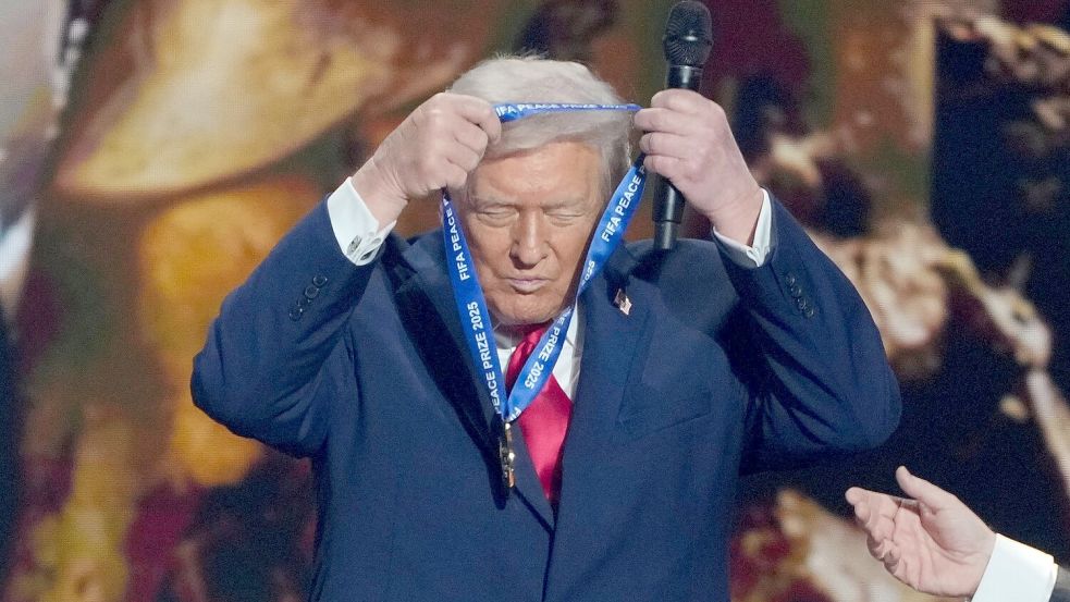 US-Präsident Trump hängt sich die FIFA-Medaille selber um. Foto: Chris Carlson/AP/dpa
