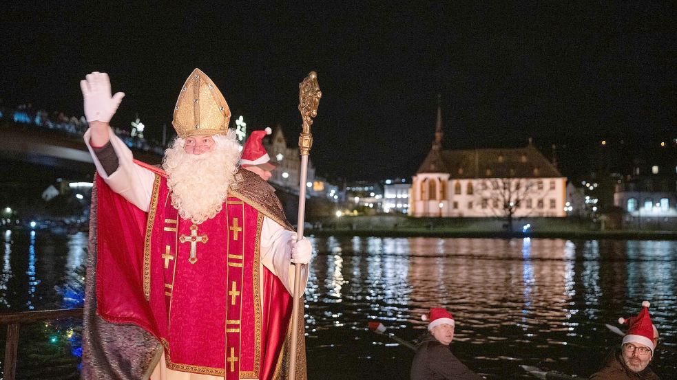 Von zahlreichen Fackelschwimmern begleitet ist der Nikolaus in Bernkastel-Kues in einem Ruderboot über die Mosel gekommen. Foto: Harald Tittel