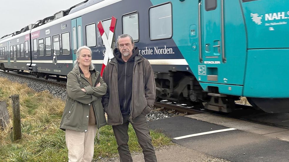Seit Oktober 2024 setzt die Nordbahn neue Akku-Züge auf der Strecke Kiel nach Flensburg ein. Seit etwa Mai werden dabei neue und lautere Hup-Töne von den Zugführern vor der Anfahrt an den unbeschrankten Bahnübergang im Mühlenweg in Basdorf abgegeben. Volker Zimmer und Dorothée Simmert wohnen nur rund 50 Meter entfernt und wollen den Warnton der alten Dieselzüge zurück. Foto: Dirk Steinmetz