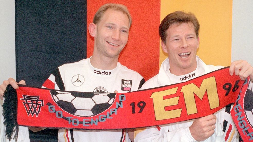 Wichtiger Baustein im defensiven Mittelfeld auf dem Weg zum Titel: Dieter Eilts (links) posiert 1996 mit Stefan Reuter und dem offiziellen EM-Schal. Die DFB-Auswahl holte am Ende den Europameistertitel nach Deutschland. Foto: Oliver Berg (dpa)
