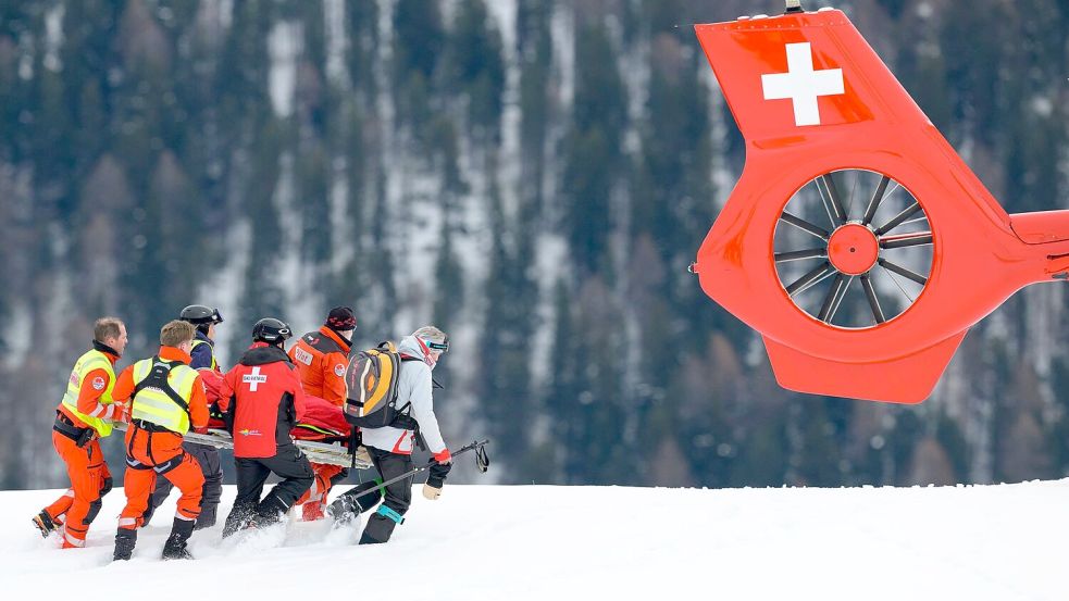 Michelle Gisin wird nach ihrem Sturz in St. Moritz zum Rettungshubschrauber gebracht. Foto: Jean-Christophe Bott/KEYSTONE/dp