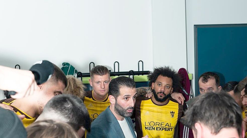 Zwei Fußballgrößen der früheren Vergangenheit lauschen seinen Worten: Trainer Majid Cirousse (Mitte) stimmt sein Team um Toni Kroos (li.) und Marcelo (re.) auf das Spiel ein. Foto: Patrick Schwan