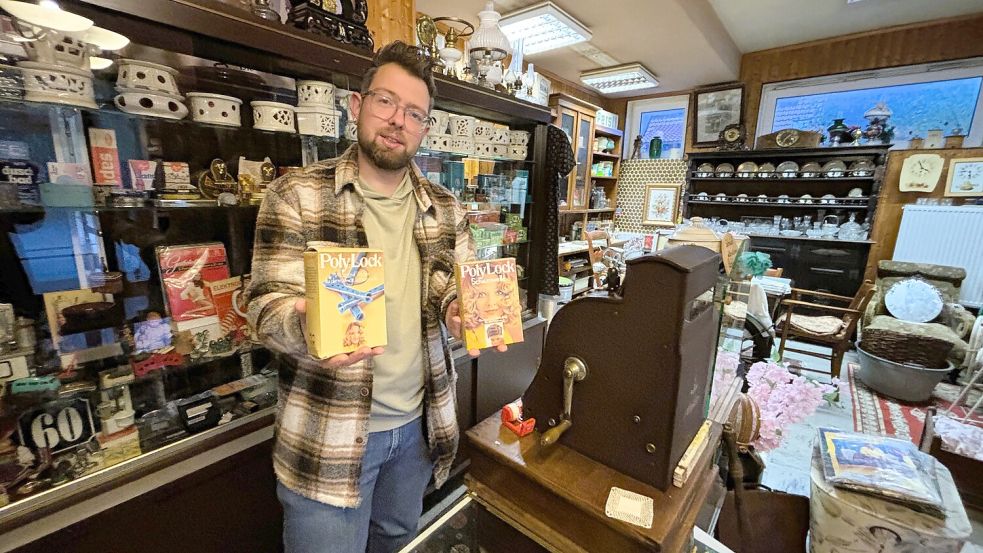 Daniel Ocken-Janssen präsentiert einige der historischen Produkte, die noch aus dem Salon stammen. Auch Tresen und Vitrine sind noch original. Foto: Nicole Böning