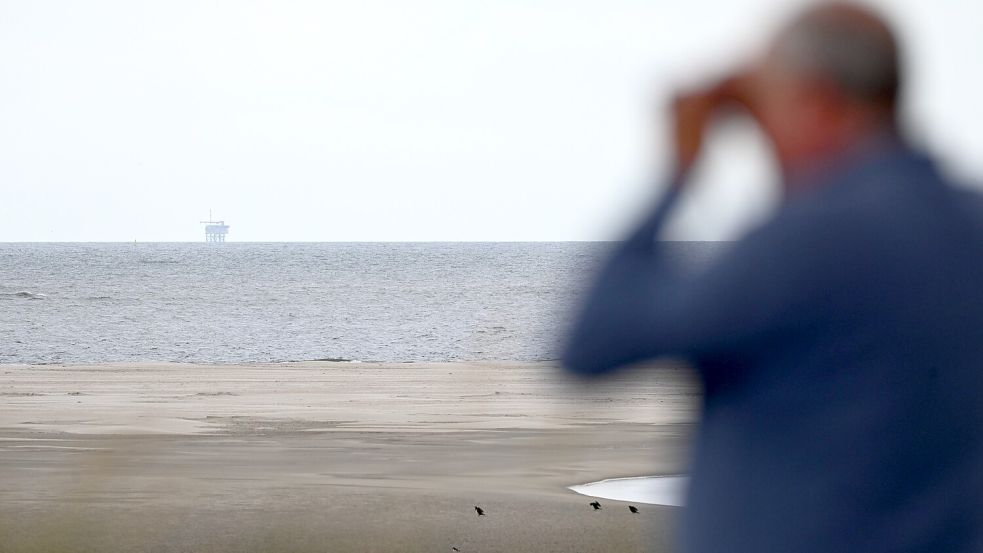 Ein Urlauber blickt auf die Gasplattform NO5-A des Unternehmens One-Dyas vor Borkum. Foto: Lars Penning/dpa