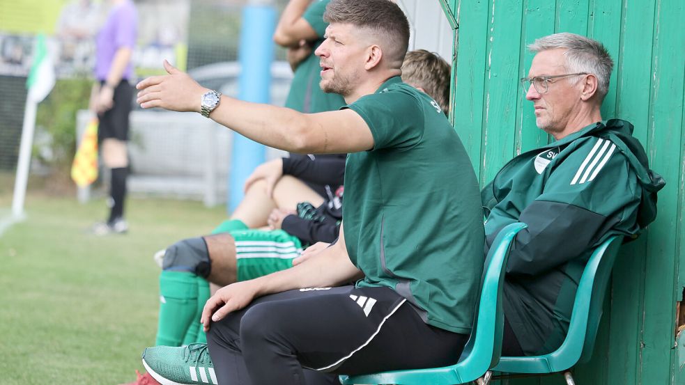 Das Gespann Trainer Max Beccard (links) und Kotrainer Ewald Mühlenbrock verfolgen das Geschehen bei den Heimspielen, während sie auf grünen Plastikstühlen sitzen. Foto: Helmut Vortanz