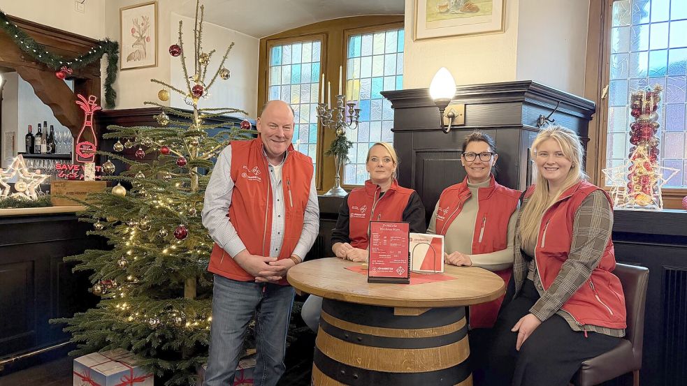 Die Johanniter und der OSC betreiben aktuell den Ratskeller, damit er während des Weihnachtsmarkts nicht leer steht. Der Erlös kommt einem guten Zweck zugute. Davon erzählen Kai Müller, Katja Könker und Anna Schmidt von den Johannitern (dritte und vierte von links) und Nadine Cooper vom OSC. Foto: Noah Schnarre