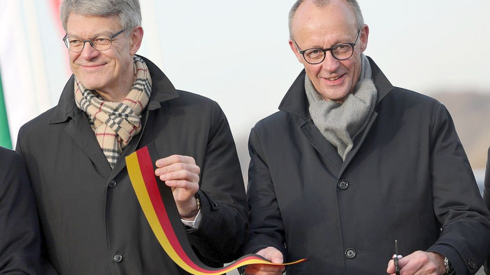 Gelöste Gesichter: Bundesverkehrsminister Patrick Schnieder und Bundeskanzler Friedrich Merz (beide CDU) durchschneiden ein Band bei der Eröffnung der Rahmedetalbrücke. Foto: dpa/Rolf Vennenbernd