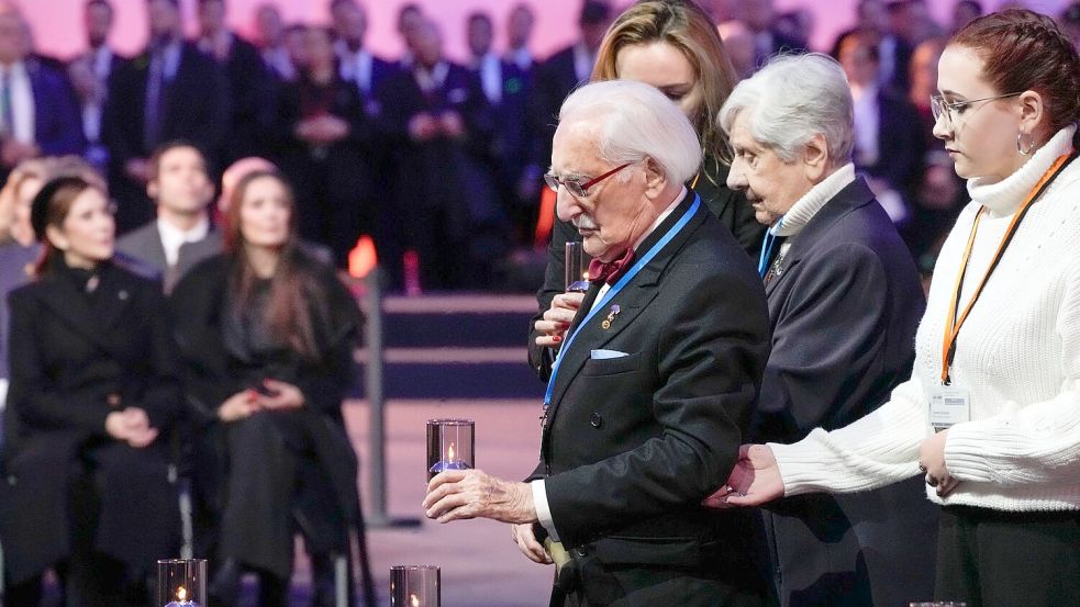Bei der Gedenkfeier zum 80. Jahrestag der Befreiung des ehemaligen deutschen Konzentrations- und Vernichtungslagers Auschwitz-Birkenau stellt Leon Weintraub eine Kerze auf. (Archivbild) Foto: Czarek Sokolowski/AP/dpa