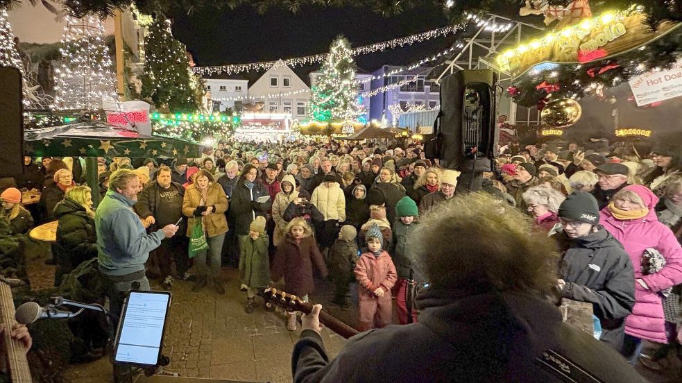 Nördlich der Markthalle, am Weihnachtsdorf in Aurich, war es proppenvoll, als um 18 Uhr das erste Auricher Weihnachtssingen begann. Foto: Karin Böhmer