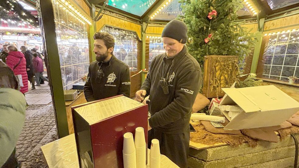 Zwei Mitarbeiter des Glühweinstandes Alt-Ostfriesland schenkten unter dem Weihnachtsbaum Glühwein und Apfelpunsch zum Sonderpreis aus. Foto: Karin Böhmer