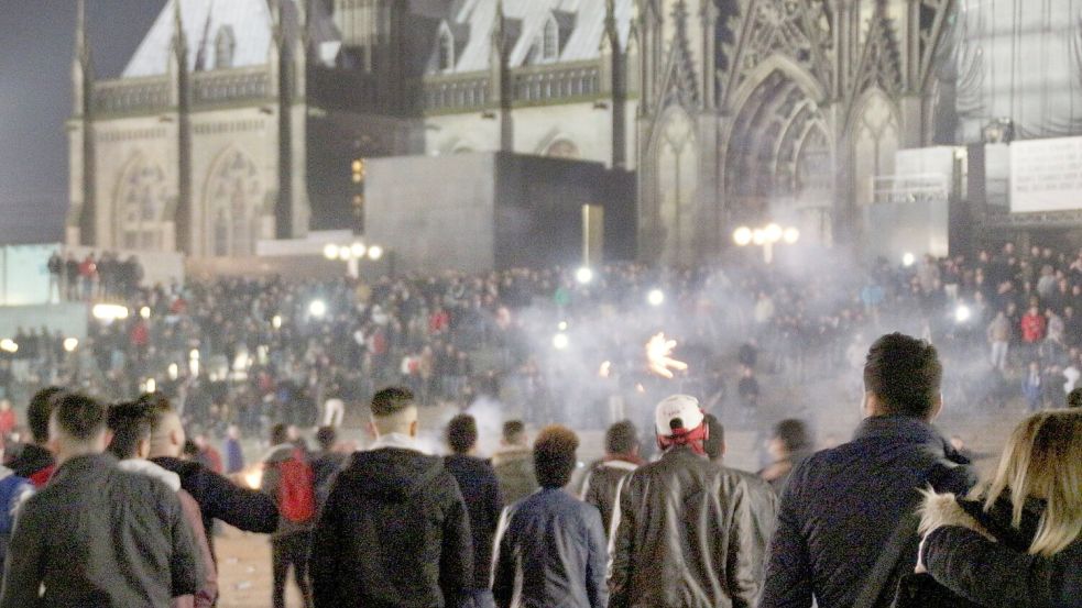 Junge Männer auf dem Platz vor dem Dom und keine Polizei weit und breit - so blieb die Kölner Silvesternacht visuell in Erinnerung. Viele Frauen wurden in der Nacht Opfer sexueller Übergriffe. (Archivbild) Foto: picture alliance / Markus Boehm/