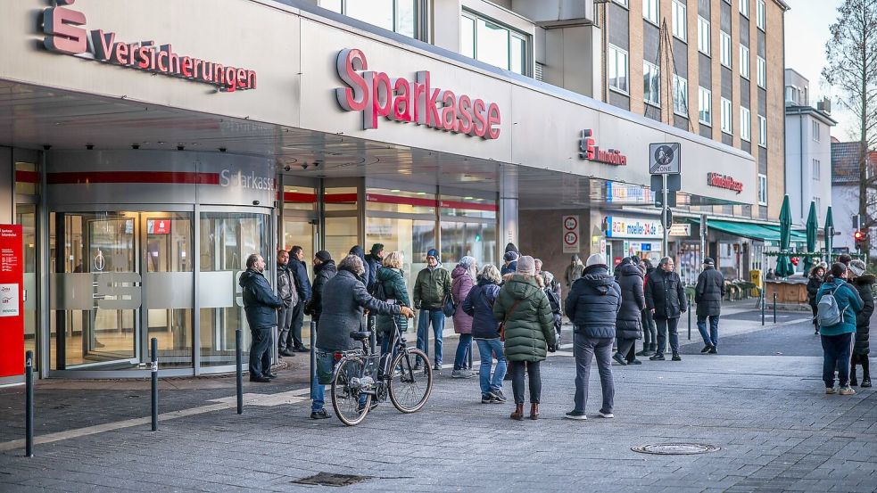 Nach einem Einbruch in den Tresorraum einer Bankfiliale in Gelsenkirchen warten Menschen vor dem Eingang auf Informationen. Foto: Christoph Reichwein