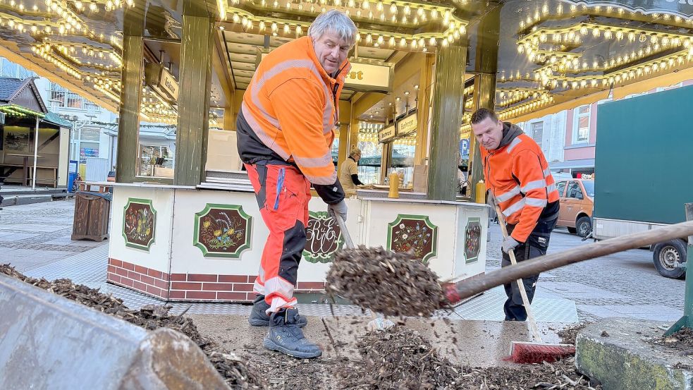 Klar Schiff vor dem Jahreswechsel: Bauhofmitarbeiter schippen und fegen am Dienstagvormittag den Rindenmulch rund um den Kugelbrunnen weg. Foto: Christin Wetzel