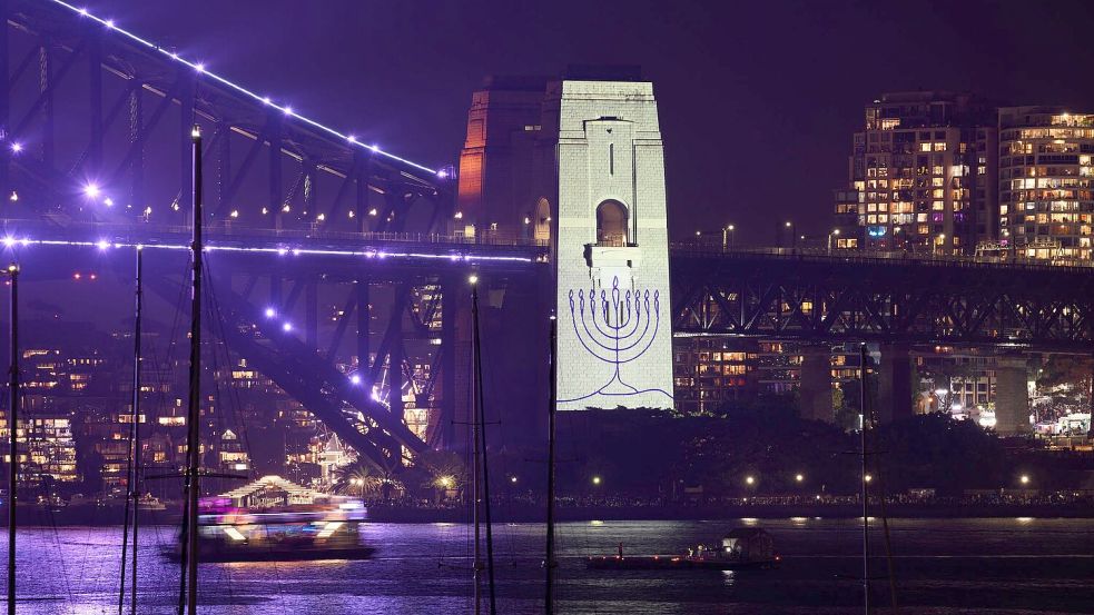 Während einer Schweigeminute wurde ein Chanukkaleuchter auf einen Pfeiler der Sydney Harbour Bridge projiziert. Foto: Dan Himbrechts