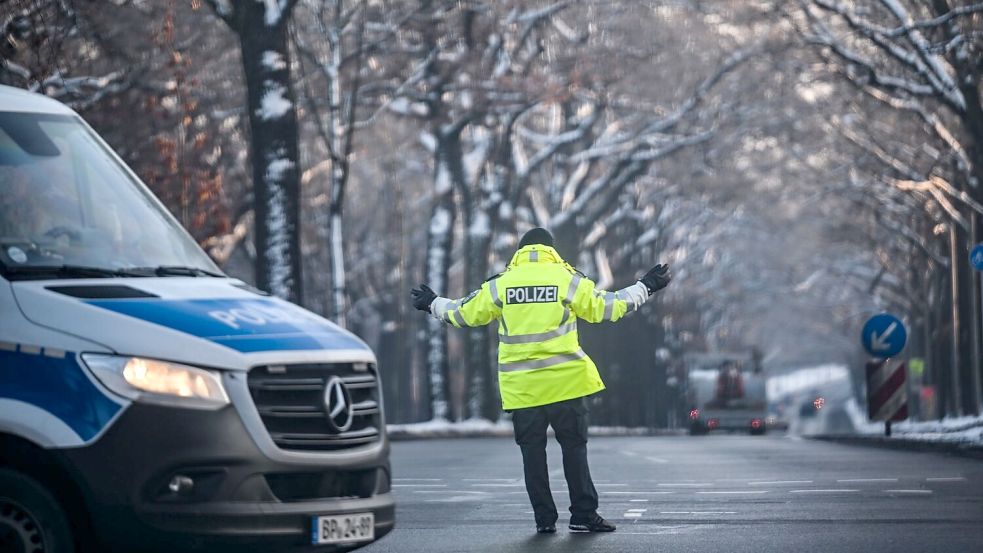 Ein Polizist regelt den Verkehr an einer Kreuzung, an der die Ampel ausgefallen ist. Foto: Britta Pedersen/dpa